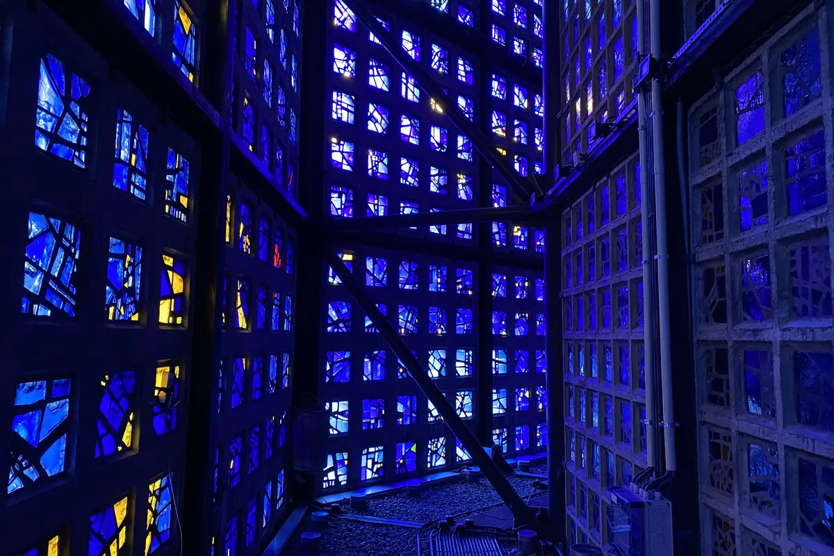 The narrow passage between the inner and outer walls of the Memorial Church, lined with blue and yellow glass panes set in concrete honeycomb frames